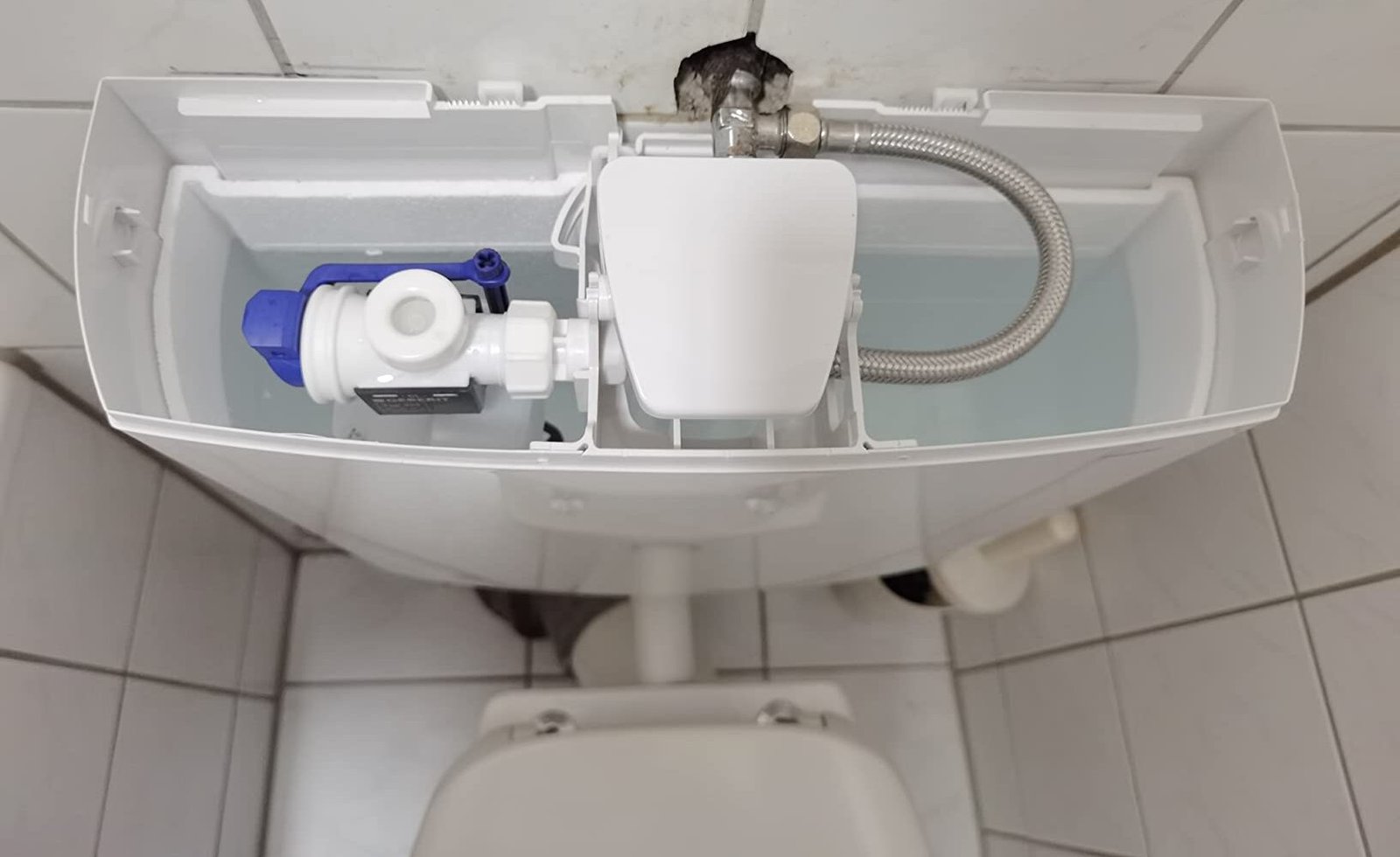 Spülkasten einer Toilette in ruhiger, ordentlicher Umgebung.