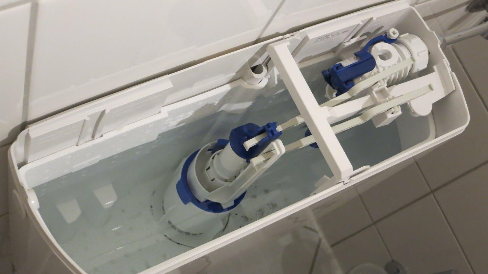 Geöffneter Spülkasten mit sichtbarem Wasserstand in ruhiger Umgebung.